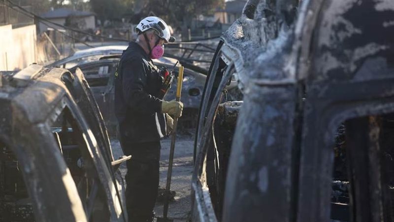 رجل إطفاء يتفقد سيارة