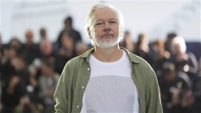 مؤسس ويكيليكس يرتدي قميصًا بأسماء 4986 طفلاً فلسطينيًا قتلهم الاحتلال خلال عامين