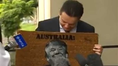 رئيس وزراء أستراليا يطبع صورة ترامب على ممسحة الأحذية ويشهرها في مؤتمر صحفي