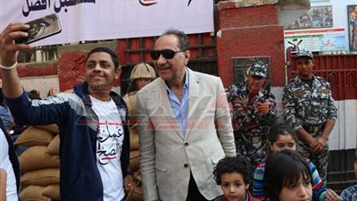 محمد أبو داود يلتقط الصور مع الجماهير بعد إدلائه بصوته في المعادي