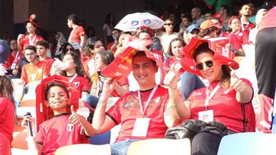 بالعلم وأوراق الدعاية والشمسيات يقاوم المصريون الشمس بمدرجات استاد القاهرة