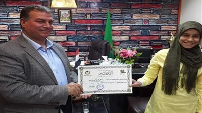 تكريم طالبة في افتتاح مدرسة دفنو الإعدادية بالفيوم
