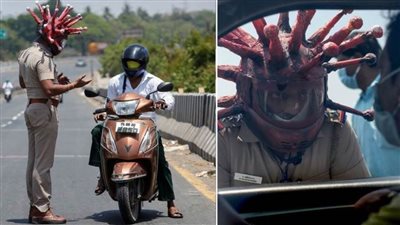 شرطي يرتدي خوذة فيروس كورونا لحث الناس على البقاء في البيوت