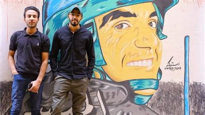 طالب بجامعة أسيوط يرسم لوحة فنية تجسد الشهيد 