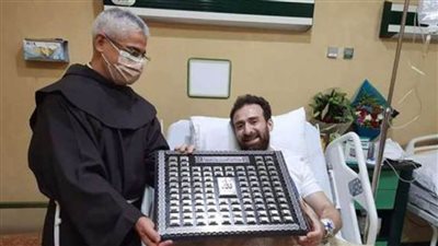 الأب بطرس دنيال يزور الفنان نضال الشافعي في المستشفى ويهديه أسماء الله الحسنى