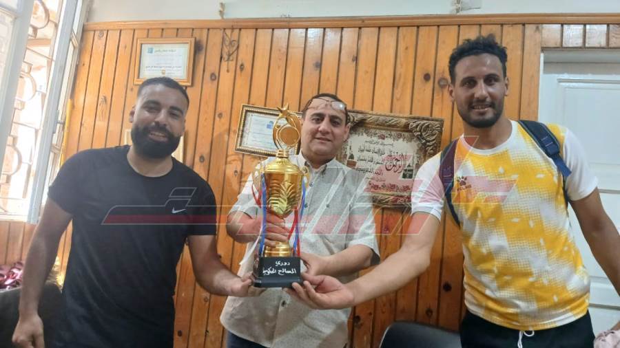 الدكتور حمادة حسن يحمل الكأس وسط الفريق