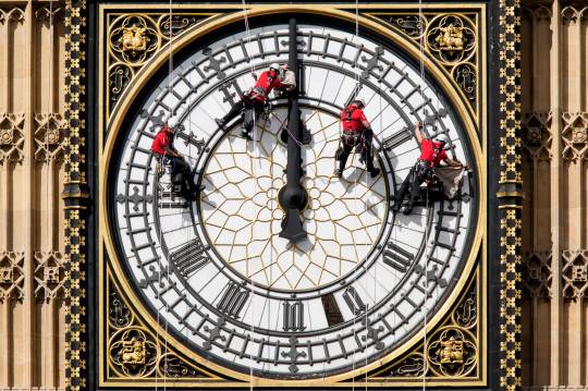  عمال ينظفون وجه الساعة المواجه للشرق لبرج إليزابيث في مجلسي البرلمان في 19 أغسطس 2014 
