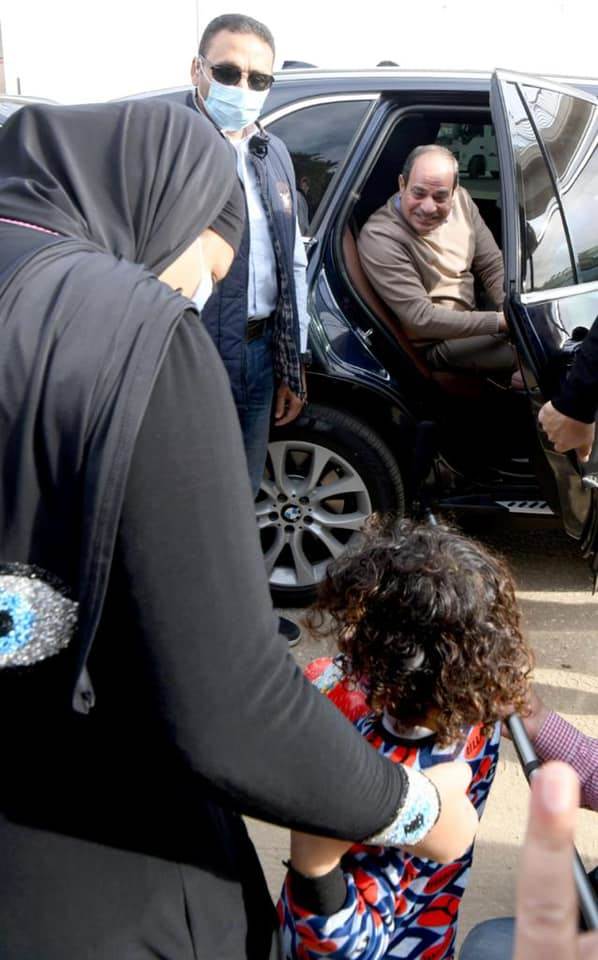 الرئيس السيسي يسلم على سيدة أثناء جولته