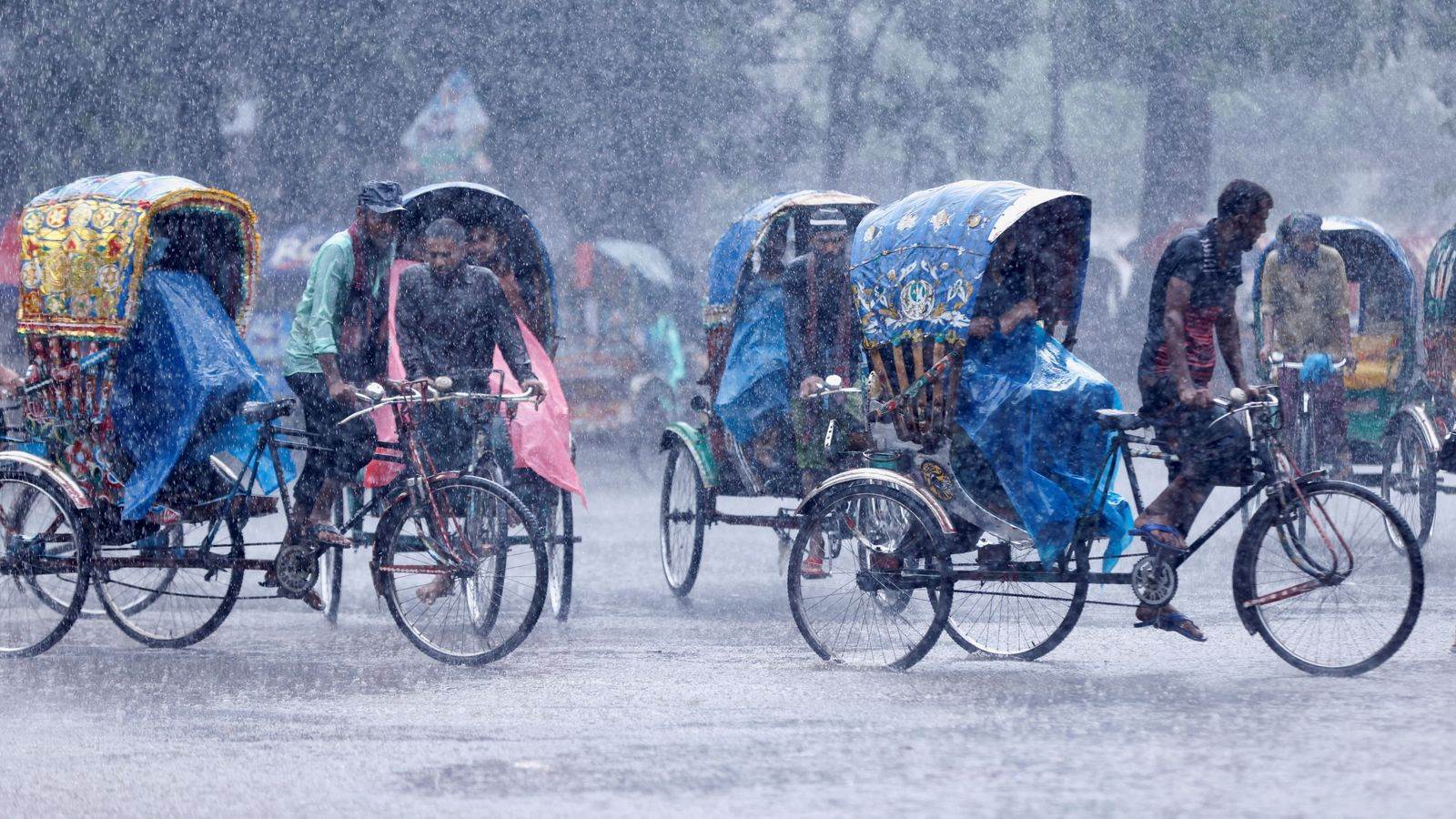 سائقو عربات الريكاشة خلال هطول أمطار غزيرة على العاصمة دكا