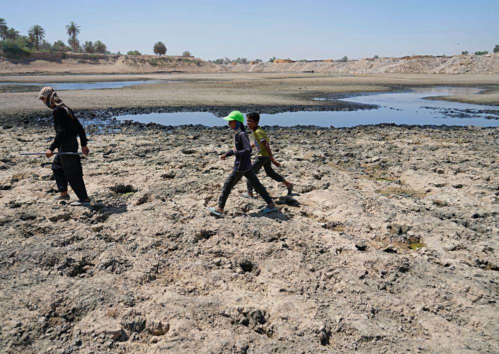 الناس يعبرون نهر ديالى ، أحد روافد نهر دجلة ، حيث أثار انخفاض منسوب المياه هذا العام القلق بين السكان بالقرب من بغداد ، العراق