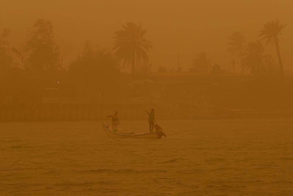 صيادون يبحرون في مجرى شط العرب المائي خلال عاصفة رملية في البصرة ، العراق 