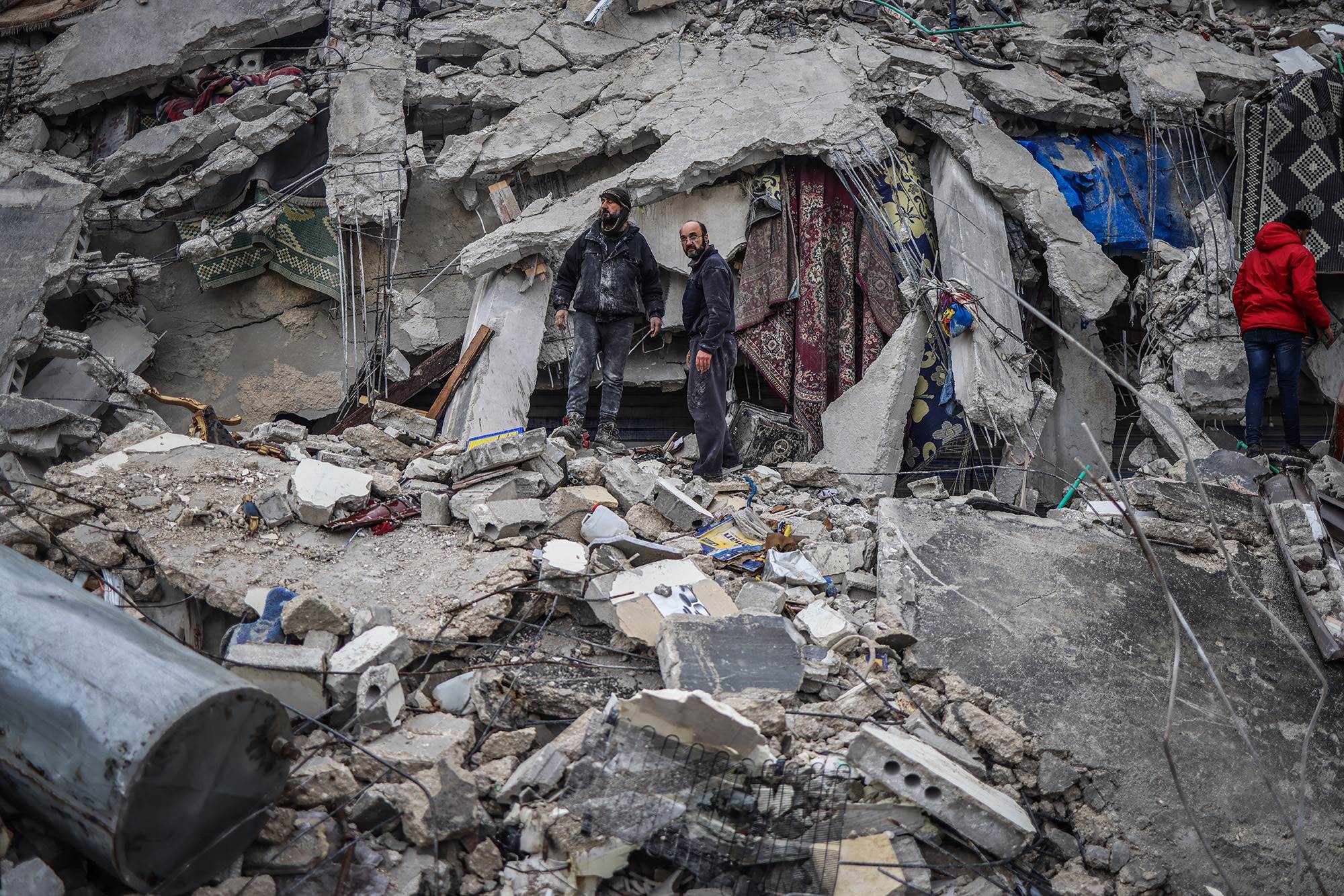  مدنيون سوريون يعملون على إنقاذ أشخاص محاصرين تحت مبنى مدمر في إدلب السورية، اليوم الاثنين