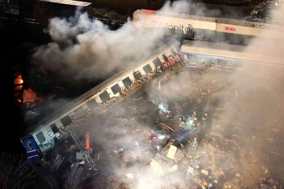 الدخان يتصاعد من القطارات بينما يعمل رجال الإطفاء والإنقاذ انتشال الضحايا والمصابين بعد اصطدام بالقرب من مدينة لاريسا، اليونانية