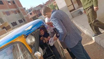 رئيس لجنة يساعد سيدة مسنة للإدلاء بصوتها في الشرقية